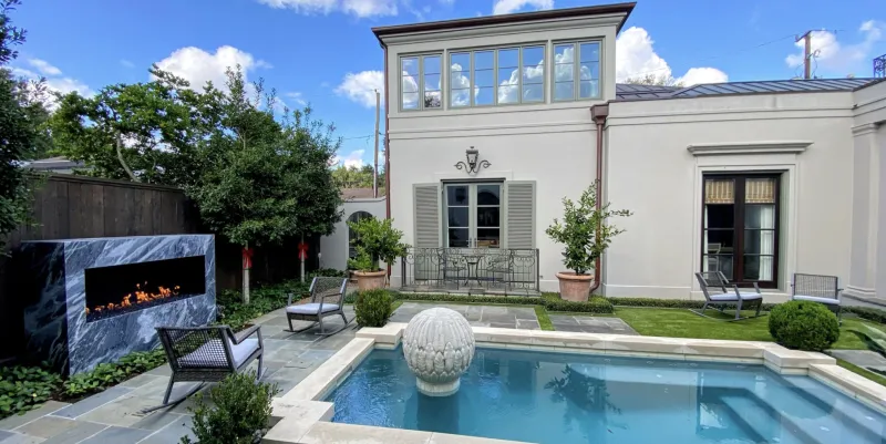 Acucraft outdoor fireplace by pool with tall flames