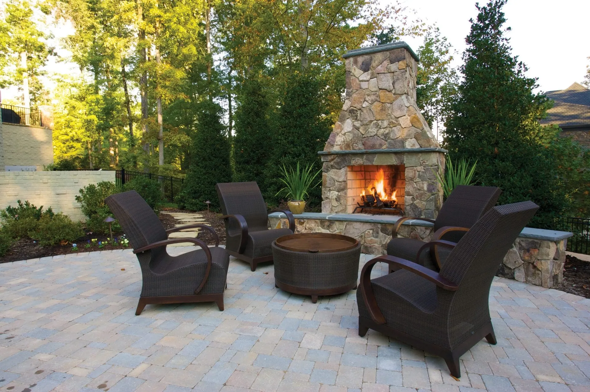 Isokern Standard Series outdoor stone fireplace with fire burning on patio