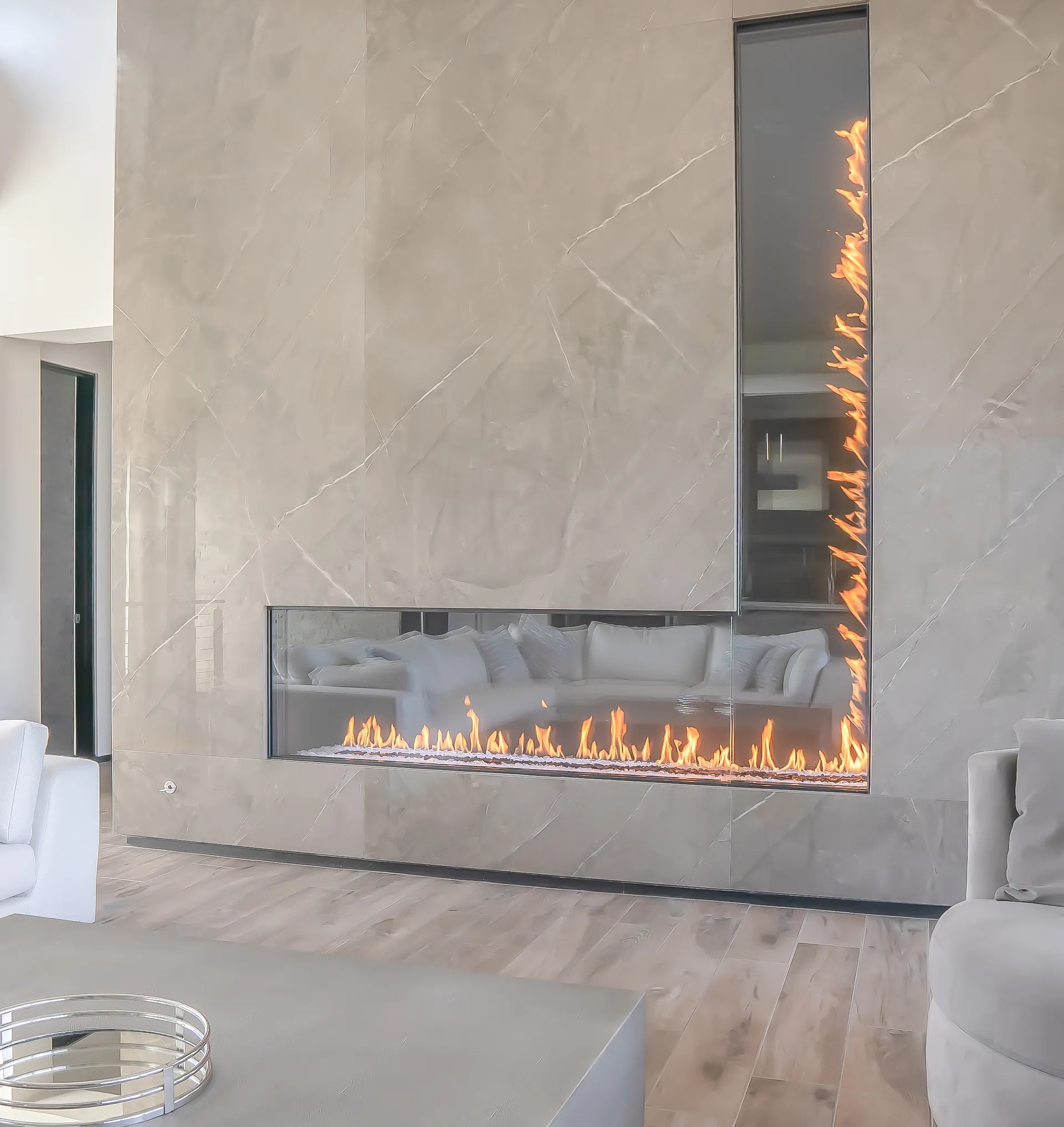Stellar custom see-through fireplace in marble wall with tall flames